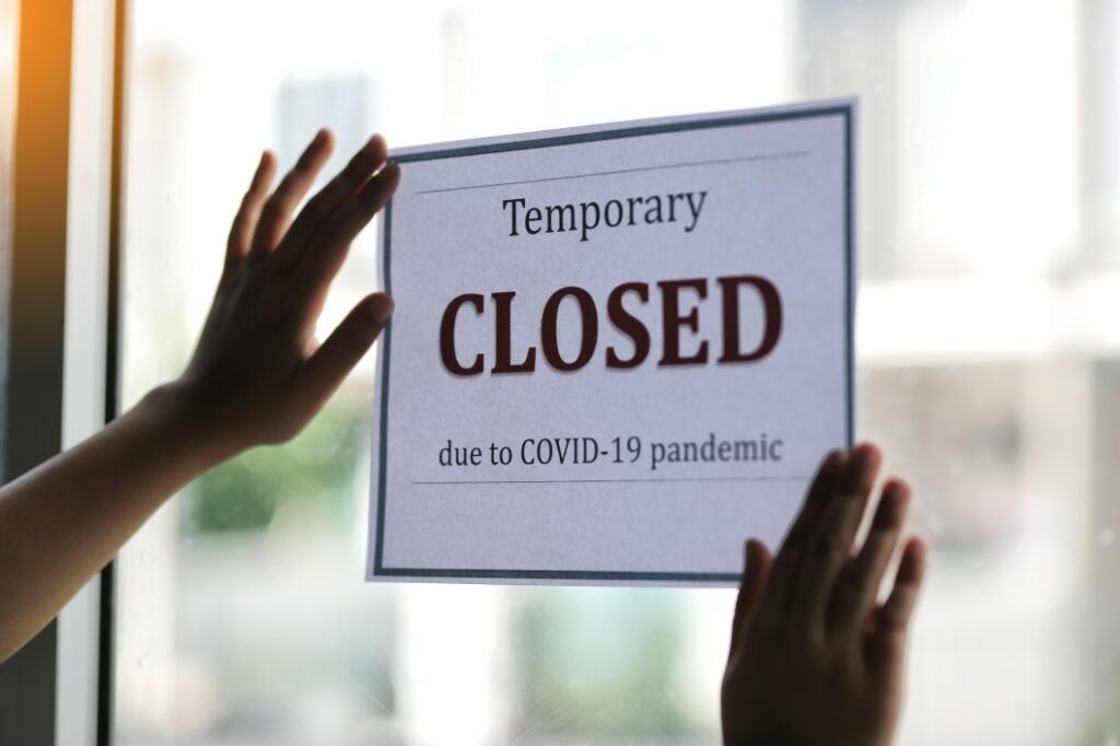 Sign on window reads, "temporarily closed due to covid-19 pandemic. "