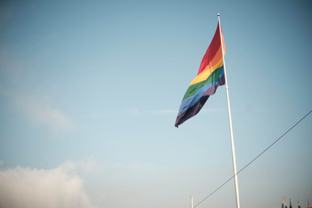 a pride flag flying on a flagpole