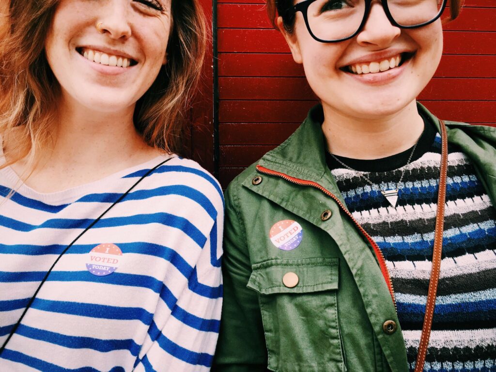 Two happy young women wearing i voted stickers