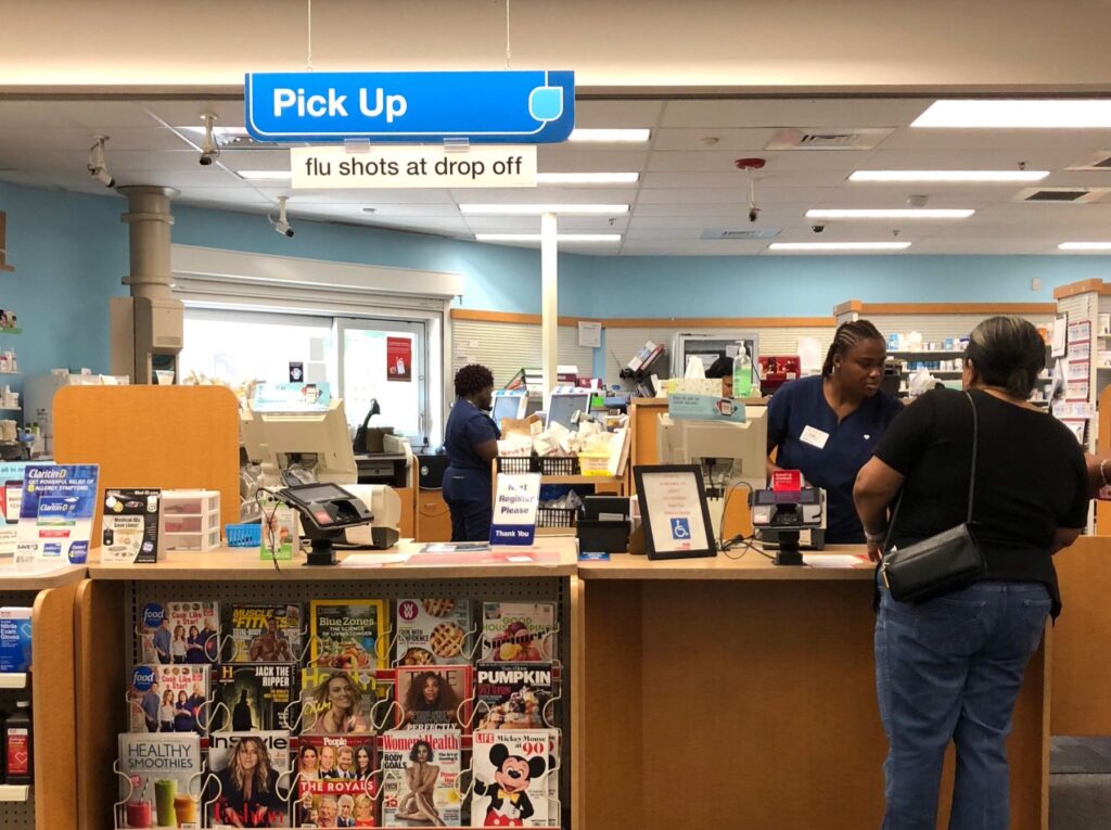 Pharmacist and customer interacting at a retail pharmacy