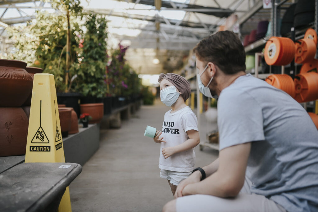 Parent and child with masks in garden store