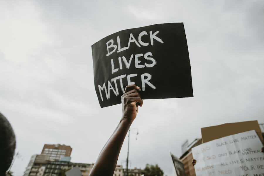 Holding sign that reads, "Black Lives Matter"