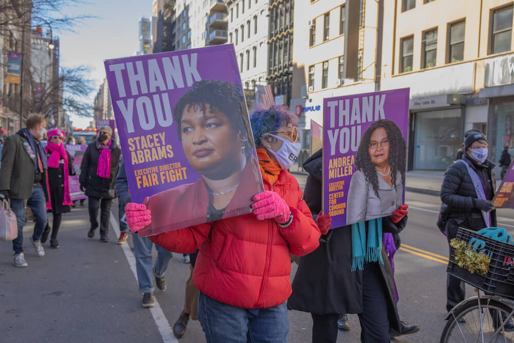 Demonstrators carry signs thanking Stacey Abrams and Andrea Miller at a Manhattan rally in support of the Equal Rights Amendment.