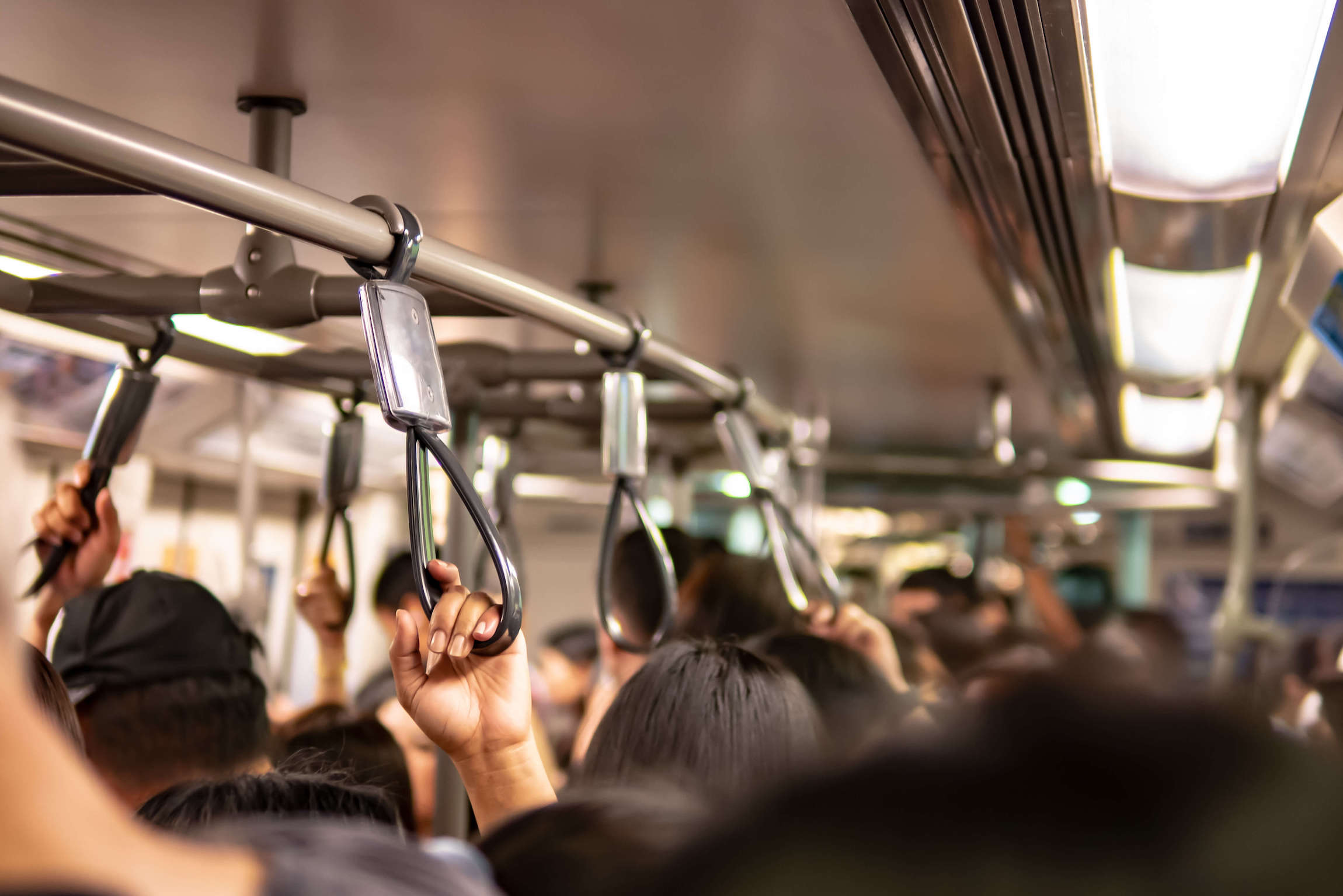 Crowd inside subway train holds straphangers