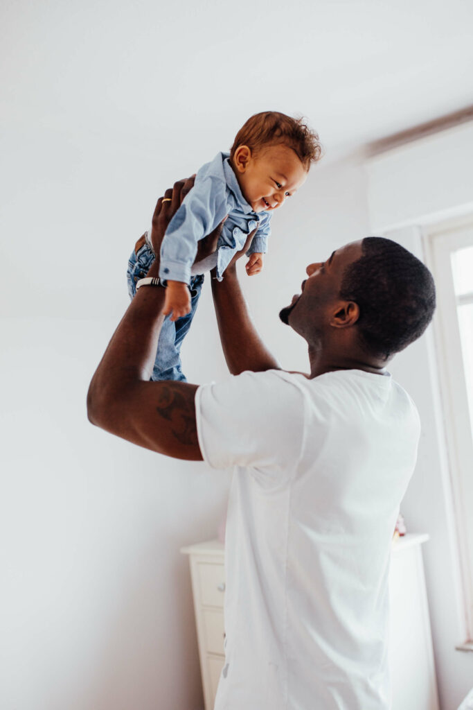 Black father smiling with baby parent